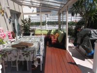 Un patio con una mesa y sillas y un sofá. en LES TROENES, en Ouistreham