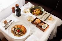 キュスナハトにあるBoutiquehotel Sonne Küsnacht - Zürichの白いテーブル(一皿の料理とワイン付)