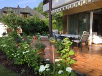 a patio with a table and chairs and flowers at Ferienwohnung Fritz in Villach