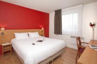 ein Hotelzimmer mit einem weißen Bett und einer roten Wand in der Unterkunft Séjours &amp; Affaires Lyon Saxe-Gambetta in Lyon