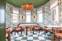 un restaurante con sillas rosas, mesas y ventanas en One Shot Puerta Ruzafa, en Valencia