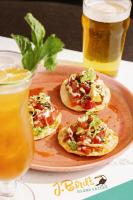 three small pizzas on a plate next to two drinks at Hilton Garden Inn Cape Canaveral Near Cocoa Beach in Cape Canaveral