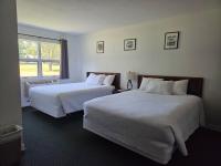 Una habitación de hotel con dos camas y una ventana. en Stowe Motel &amp; Snowdrift, en Stowe