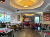 Un restaurante con mesas y sillas y un techo. en Logis Auberge Saint Simond, en Aix-les-Bains