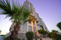 a building with a palm tree in front of it at Seven Palaces Hotel in Hafr Al Baten