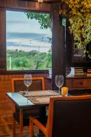 einen Tisch und Stühle mit Weingläsern auf der Terrasse in der Unterkunft Coração da Terra Praia do Rosa in Praia do Rosa