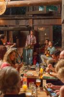 Eine Gruppe von Menschen, die mit einem Mann auf der Bühne am Tisch sitzen. in der Unterkunft Coração da Terra Praia do Rosa in Praia do Rosa