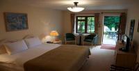 Un dormitorio con una cama y una mesa con sillas. en Donnington Grove Hotel &amp; Golf Club, en Newbury