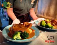 Dos platos de comida con brócoli en una mesa. en The George and Dragon Pub, en Shipley