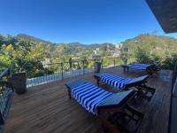 Una terraza con dos tumbonas y sillas. en Ella Rawana Den Hotel, en Ella