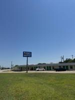 un edificio con una señal en medio de un campo en Budget Inn Port Lavaca, en Port Lavaca