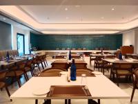 a restaurant with tables and chairs and a greenboard at Kenilworth in Visakhapatnam