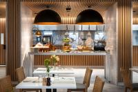 un restaurante con mesa y sillas y una cocina en Holiday Inn Melbourne Bourke Street Mall by IHG, en Melbourne