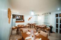 une salle à manger avec des tables et des chaises en bois dans l'établissement Heaven Hill Apartments - Arusha, à Arusha