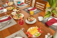 a wooden table with plates of food and a glass of wine at Sala Hoi An Hotel in Hoi An