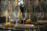 un tavolo con bicchieri da vino e un vaso con fiori di HH Riz Resort - Adults Only a Maspalomas