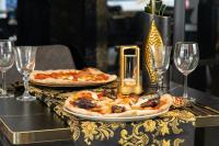 due pizze sono appoggiate su un tavolo con bicchieri di vino di HH Riz Resort - Adults Only a Maspalomas