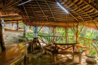 Una cabaña con una mesa y un banco dentro en Wooden Eco Cottage, en Katiyawa