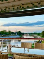 a table on a balcony with a view of a river at Dragon River Avenue in Phitsanulok