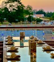 a table with plates and hats on it next to a pool at Dragon River Avenue in Phitsanulok