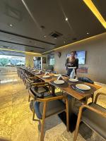a long table with chairs and a man standing in front of it at Elysian Hotels Abuja in Abuja
