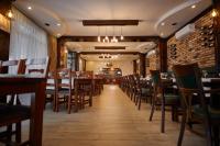 een eetkamer met houten tafels en stoelen bij Pensiunea Rami 