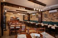 een restaurant met tafels en stoelen en een bakstenen muur bij Pensiunea Rami 