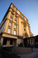 un edificio alto de color amarillo con ventanas en una calle en Nine Tree Luxury Hotel &amp; Suites Lahore, en Lahore