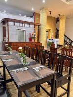 Un comedor con una mesa y sillas de madera. en Khách Sạn Và Nhà Hàng Ngọc Yến 5 Vĩnh Long, en Vĩnh Long