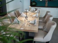 Una larga mesa de madera con sillas, vasos y servilletas. en Logis Hôtel-Restaurant Domaine de Montecristo et Gîte l'Évasion Dantès, en Bourguignons