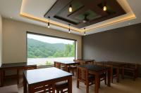 uma sala de jantar com mesas e uma grande janela em Rosa Mystica Hotels & Resorts em Anachal