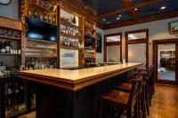 リホボスビーチにあるAvenue Inn & Spaの木製カウンターと椅子が備わるバー