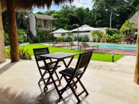 バカラルにあるNalhá Hotel Boutique y Villasのプールサイドのテーブルと椅子2脚