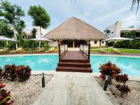 バカラルにあるNalhá Hotel Boutique y Villasのリゾート(スイミングプール、わらぶき屋根の建物付)