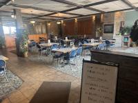 een restaurant met tafels en stoelen en een bord bij Big Horn motor Inn in Grande Cache