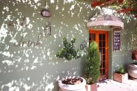 a green building with a red door and a tree at Donkin Country House in Beaufort West