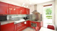 a red kitchen with red cabinets and a sink at Appart&#39; Rachais in Lyon