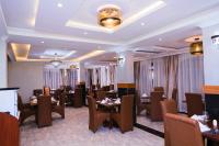 Un restaurante con mesas y sillas en una sala. en Olive Gardens Hotel Nairobi, en Nairobi