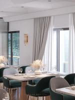 ein Esszimmer mit Tischen, Stühlen und Fenstern in der Unterkunft Diana Cruises Halong Bay - Luxury by Venus Group in Hạ Long