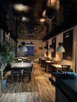 un comedor con mesas, sillas y luces colgantes en Harz Hotel Waldhaus, en Goslar