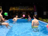 a group of men playing with a ball in a swimming pool at Pak-Up Hostel in Krabi town