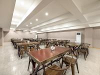 uma sala vazia com mesas e cadeiras em Kyriad Hotel em Tianjin