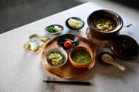 un tavolo con un piatto di cibo con ciotole di cibo di MEGURU l 巡 a Isola di Ishigaki