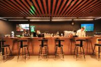 Un uomo in piedi in un bar in un ristorante di 50100 Hotel a Mörön