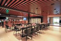 una sala da pranzo con tavoli, sedie e un bar di 50100 Hotel a Mörön