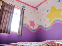a bedroom with a rainbow and stars on the wall at Sea Front Homestay in Magong