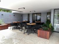 eine Gruppe von Tischen und Stühlen in einem Restaurant in der Unterkunft Flat aconchegante a 50m do mar do Bessa - até 4 pessoas in João Pessoa