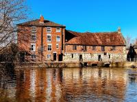 un gran edificio de ladrillo junto a un río en Old Mill hotel, en Salisbury