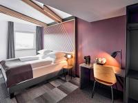 Un dormitorio con una cama, una mesa y una silla. en B&amp;B Hotel Hamm, en Hamm
