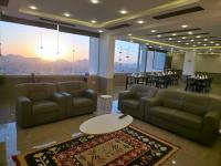 Un vestíbulo con sofás y una mesa y mesas y sillas. en The charming view, en Wadi Musa